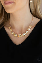 Load image into Gallery viewer, Featuring mismatched round, oval, and square cuts, a golden row of dramatically oversized rhinestones delicately link below the collar for an icy finish. Features an adjustable clasp closure. Sold as one individual necklace. Includes one pair of matching earrings.