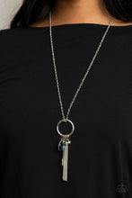 Load image into Gallery viewer, A blue teardrop gem, silver key, dainty crystal-like bead, and shimmery silver chain tassel swings from the bottom of a silver ring at the bottom of a lengthened silver chain, creating a whimsically tasseled display. Features an adjustable clasp closure.