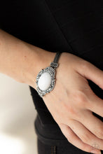 Load image into Gallery viewer, Hematite encrusted silver frames delicately overlap around an oval white bead, creating an edgy centerpiece. The colorful centerpiece attaches to strands of ornate silver chains that are held in place around the wrist by studded silver frames. Features an adjustable clasp closure.