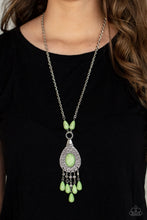 Load image into Gallery viewer, Paparazzi - Cowgirl Couture - Green - An Apple Green oval stone sits center stage surrounded by swirly designs stamped into a wide silver frame. A fringe of silver floral beads culminating in Apple Green stones swings like a pendulum at the end of a lengthened silver chain for a fashionable finish