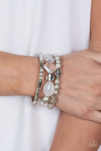 Load image into Gallery viewer, Marina Magic - Paparazzi - Infused with enchanting pops of white crystal-like and glassy accents, a mismatched assortment of hammered, cube, and faceted silver beads are threaded along stretchy bands around the wrist, creating shimmery layers.