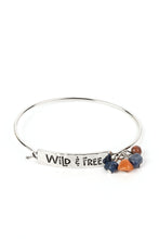 Load image into Gallery viewer, Paparazzi - Fearless Fashionista - Blue - The words "Wild & Free" are stamped across a thick plate of silver in a playful font. An orange stone and two lapis stones combine with a brown wooden bead, gathering at the side of the inspirational centerpiece as it connects to a skinny silver bar that wraps around the wrist.