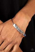 Load image into Gallery viewer, Paparazzi - Fearless Fashionista - Blue - The words "Wild & Free" are stamped across a thick plate of silver in a playful font. An orange stone and two lapis stones combine with a brown wooden bead, gathering at the side of the inspirational centerpiece as it connects to a skinny silver bar that wraps around the wrist.