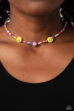 Load image into Gallery viewer, Paparazzi - Flower Power Pageant - Purple - Multicolored seed beads, featuring lavender, green, pink, pearly pink, blue, orange, purple, yellow, and dark green, are threaded along a wire, falling along the collar in a capricious pattern. Bringing additional charm to the design, yellow smiley face beads, and a purple flower with a yellow smiley face center, blooms amongst the bright pops of color.