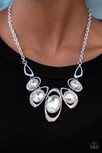 Load image into Gallery viewer, Hypnotic Twinkle - White - Dusted in sections of glassy white rhinestones, asymmetrical silver frames curl around oversized white gems below the collar. Varying in shape, the mismatched frames increase in size as they near the center for a hypnotizing finish. - Paparazzi