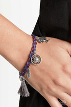 Load image into Gallery viewer, Paparazzi - Outdoor Enthusiast - Multi-Color - This Black Diamond Encore is back in the spotlight: Shiny blue, red, and purple cording weaves into a colorful braid across the wrist. Radiant silver charms and a soft threaded tassel swing from the wrist in a free-spirited, wanderlust fashion.
