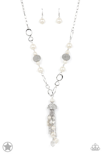 A half-shell studded in rhinestones overhangs a cluster of ivory pearls, tassels of silver chain, and small crystals. Two large wire mesh spheres and larger ivory pearls decorate the neckline.