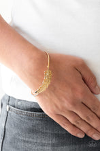 Load image into Gallery viewer, Featuring life-like detail, a shimmery gold feather folds along a dainty gold-tone cuff.
