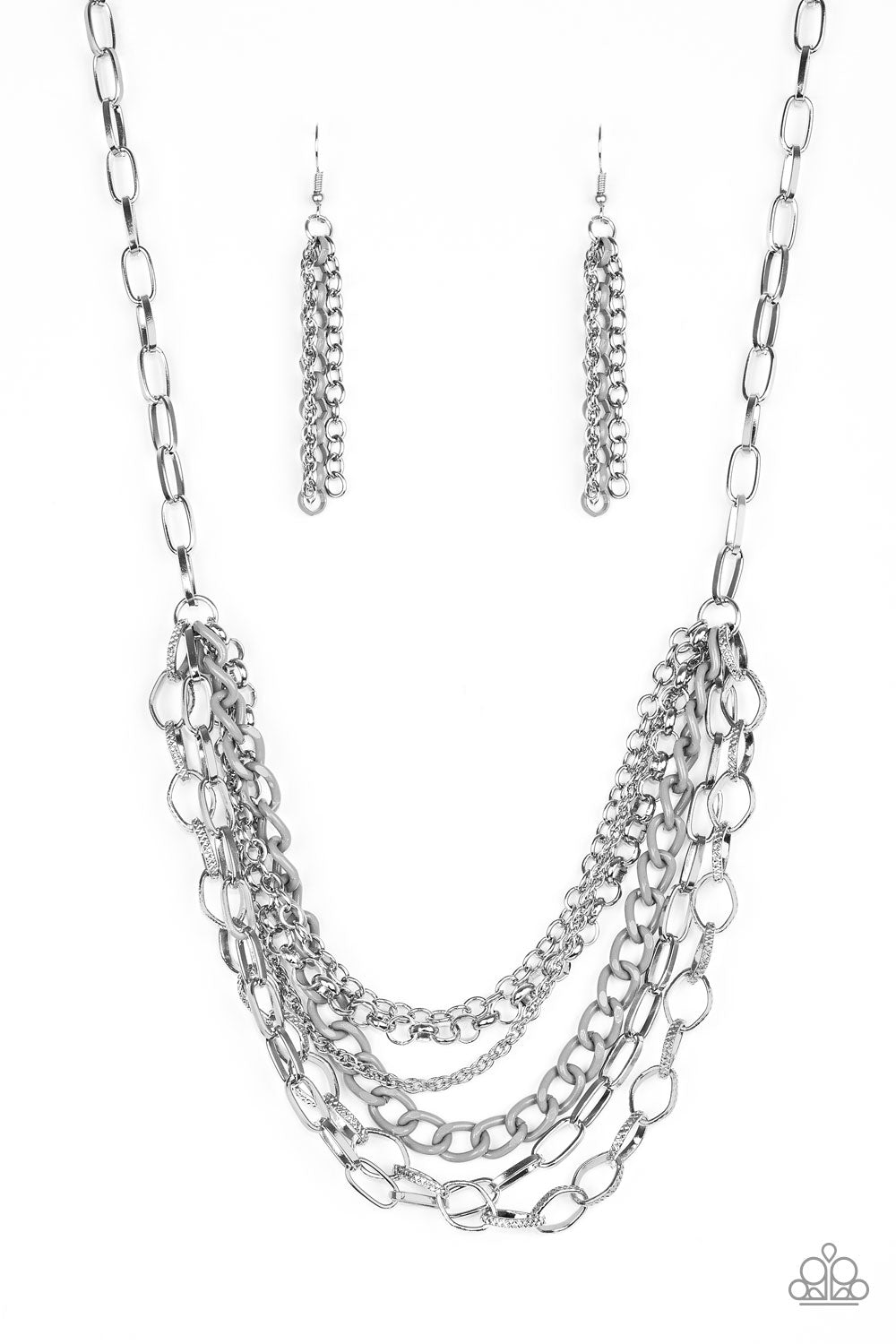 Mismatched silver chains layer below the collar for a bold industrial look. Painted in a neutral finish, a shiny gray chain drapes between the shimmery silver chains for a vivacious finish. Features an adjustable clasp closure.  Sold as one individual necklace by Paparazzi. Includes one pair of matching earrings.