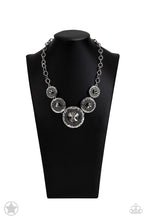 Load image into Gallery viewer, Gradually increasing in size, dramatically oversized smoky gems are pressed into the centers of hammered and silver studded frames. The blinding frames link below the collar for a glamorous, statement-making finish. Features an adjustable clasp closure.  Sold as one individual necklace. Includes one pair of matching earrings
