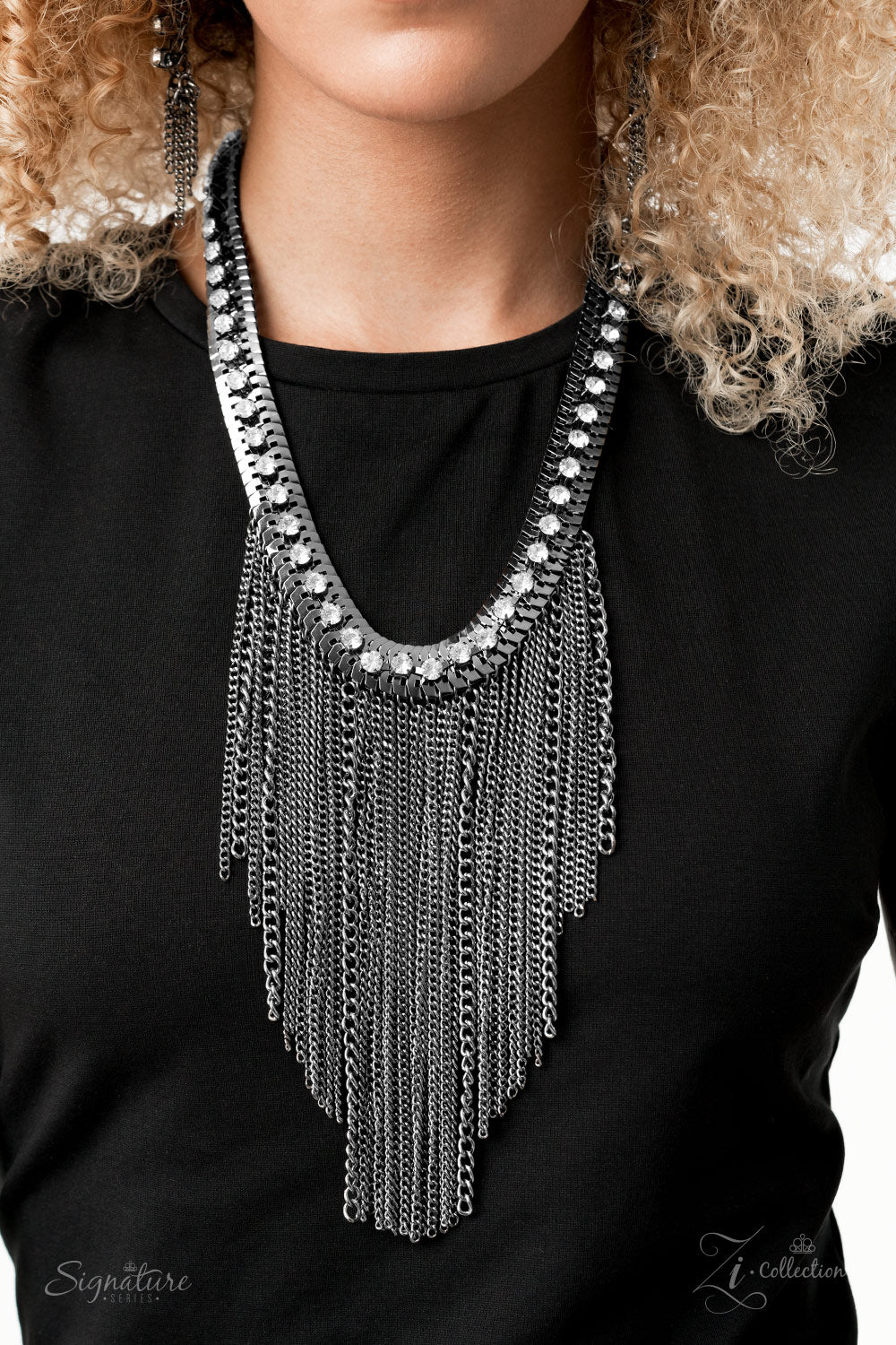 A sassy curtain of mismatched gunmetal chains tapers from the bottom of a dramatic row of glassy white rhinestones that have been delicately fastened to an edgy row of flattened gunmetal chain. The exaggerated fringe cascades down the chest, resulting in a dauntless attitude that demands attention with every swish of the fearless fringe. Features an adjustable clasp closure.