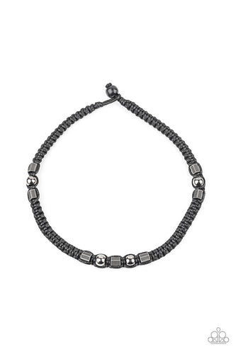 Sections of gunmetal beads and studded hexagonal accents are knotted in place along a black cord that has been braided around the neck for a seasonal look. Features a button loop closure.