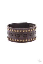 Load image into Gallery viewer, Brown laces are threaded through the center of a brown leather band that has been studded in brass accents, creating a rustic centerpiece around the wrist. Features an adjustable snap closure.

