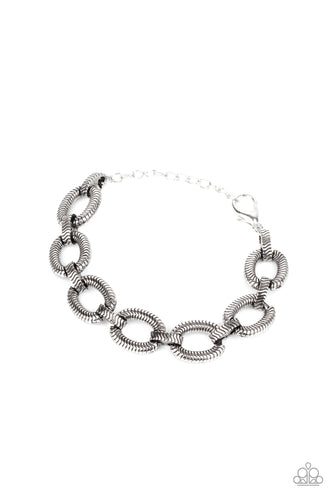 Stamped in snake chain detail, antiqued silver ovals and matching silver links interlock across the wrist for a wild industrial look. Features an adjustable clasp closure.