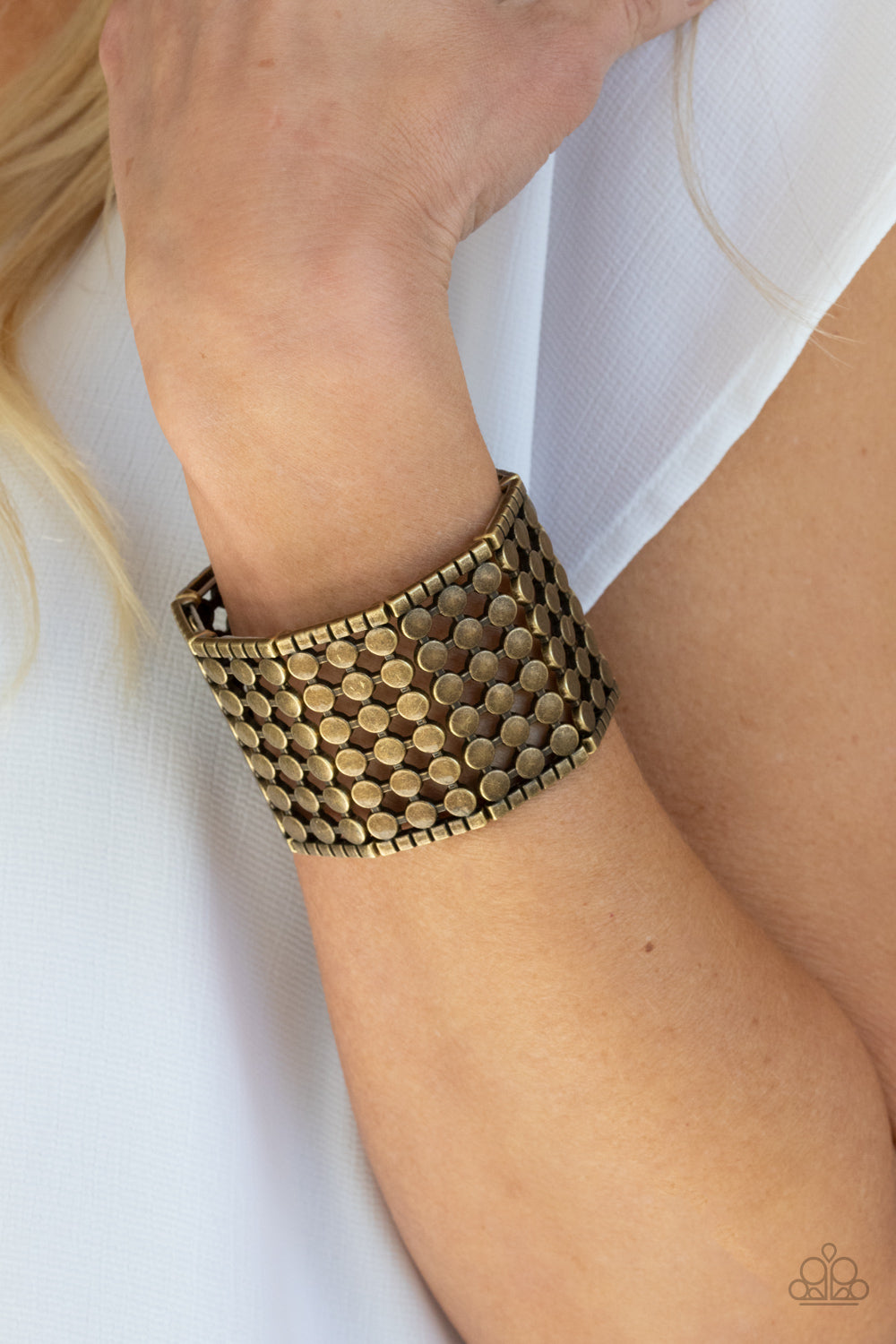 Bordered by rows of brass cubes, stacked rows of antiqued brass dots connect into rectangular frames that are threaded along stretchy bands around the wrist for an edgy geometric finish.  Sold as one individual bracelet.