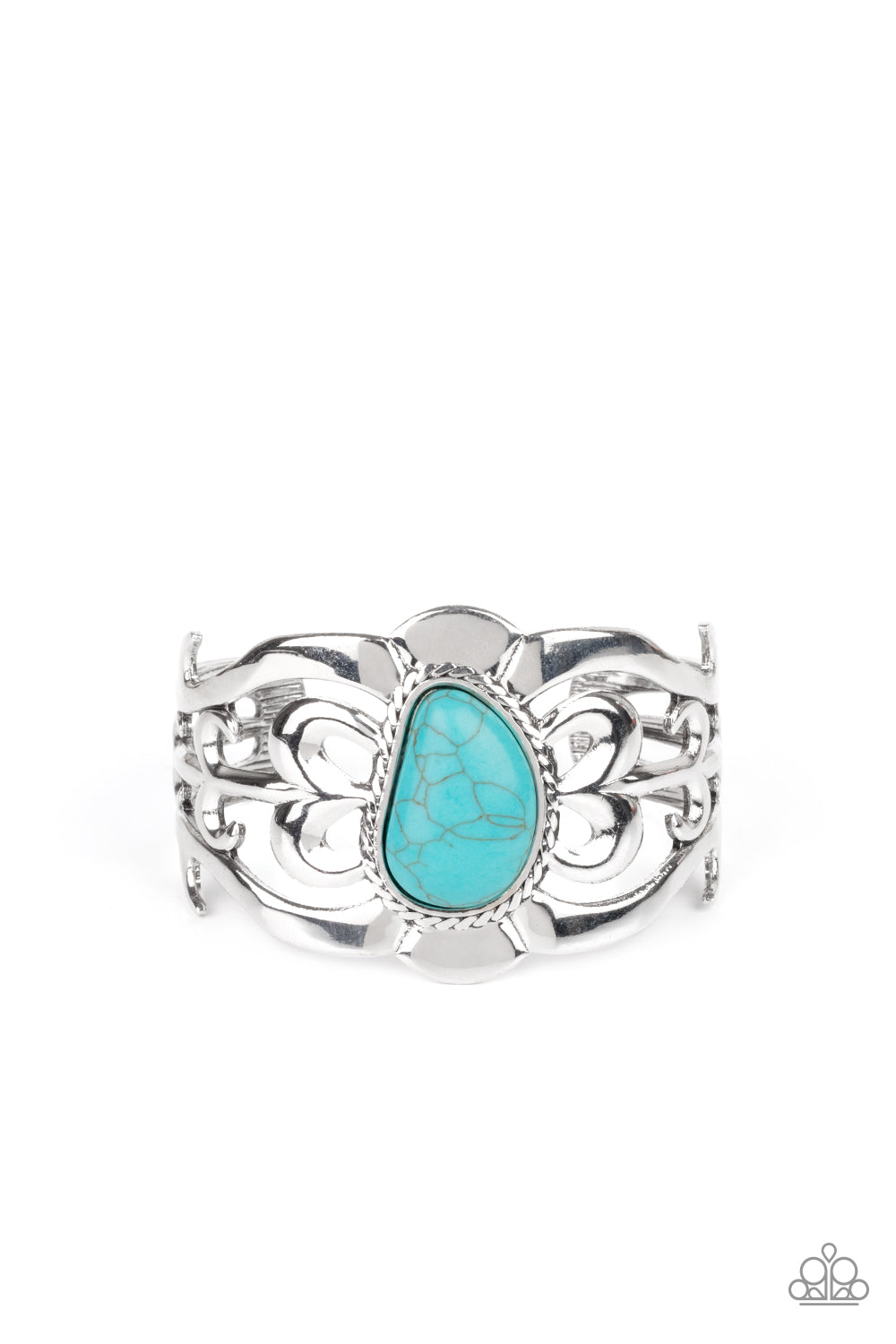 An asymmetrical turquoise stone is pressed into the center of a silver cuff layered with filigree patterns around the wrist for a rustic flair.