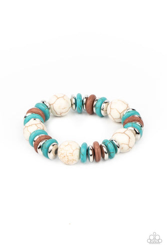 Disc shaped turquoise stones, white stones, and silvery beads join oversized white stone beads along a stretchy band, creating a rustic centerpiece around the wrist.