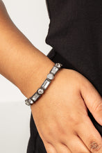 Load image into Gallery viewer, CLASSIC COUTURE - Paparazzi - Classic round and baguette-cut rhinestones set in shiny dotted gunmetal frames alternate around the wrist on stretchy bands for a shimmering finish.
