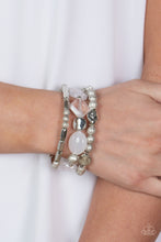 Load image into Gallery viewer, Marina Magic - Paparazzi - Infused with enchanting pops of white crystal-like and glassy accents, a mismatched assortment of hammered, cube, and faceted silver beads are threaded along stretchy bands around the wrist, creating shimmery layers.
