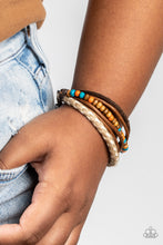 Load image into Gallery viewer, Woodsy Wayfarer - Paparazzi - An earthy combination of colorful wooden beads, shiny brown cording, a brown suede band, a brown and white braided bracelet delicately layer around the wrist for an adventurous fashion.

