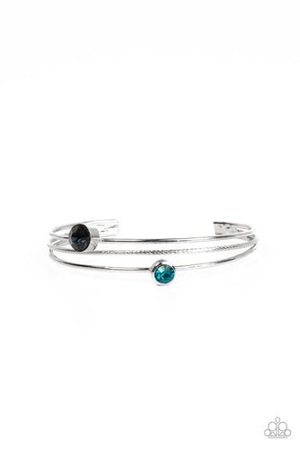 Paparazzi - Your PALACE or Mine? - Blue - A pair of dark and classic blue rhinestones sporadically adorn a layered silver cuff, creating a dainty dazzle around the wrist.