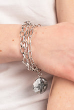 Load image into Gallery viewer, Paparazzi - True North Twinkle - Silver - Dotted with dainty hematite rhinestones, a twinkly star sparkles across the front of a hammered silver disc that delicately swings from layered silver chains around the wrist for a stellar style.
