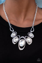 Load image into Gallery viewer, Hypnotic Twinkle - White - Dusted in sections of glassy white rhinestones, asymmetrical silver frames curl around oversized white gems below the collar. Varying in shape, the mismatched frames increase in size as they near the center for a hypnotizing finish. - Paparazzi
